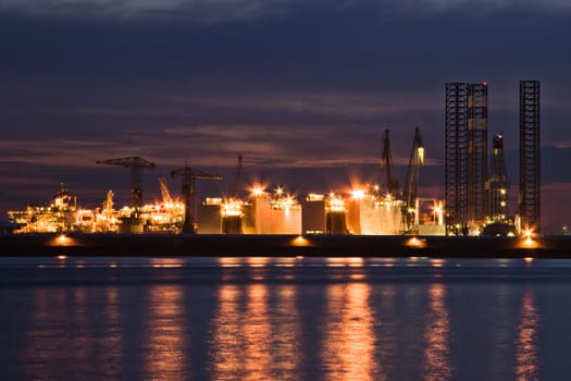 Construction- and ship-repair industry by night with reflection of the lights in the river