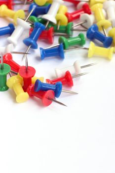 Multicolored push pins on bright background