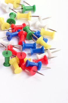 Multicolored push pins on bright background