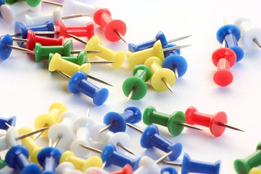 Multicolored push pins on bright background