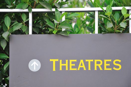 sign nestled in leaves pointing the way to theater