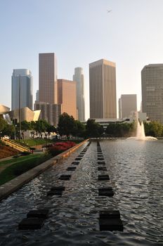 Stepping stones through a pool towards skyscrapers in the distance