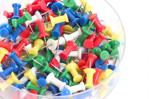 Multicolored push pins on bright background