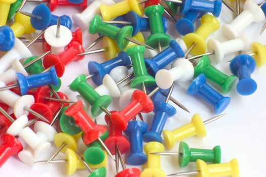 Multicolored push pins on bright background