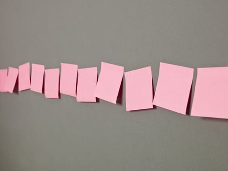 Row of Pink Adhesive Notes on grey background