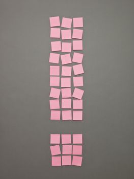 Exclamtion Mark made of Pink Adhesive Notes on grey background