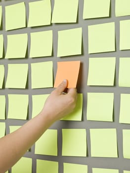 Human taking an Adhesive Note from a wall