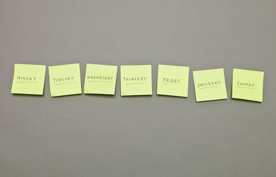 Adhesive Notes with the weekdays in a row on grey background