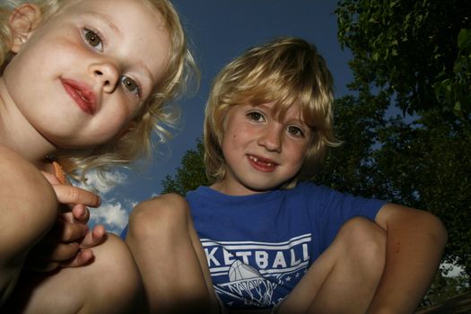 two cute siblings smiling and looking downwards