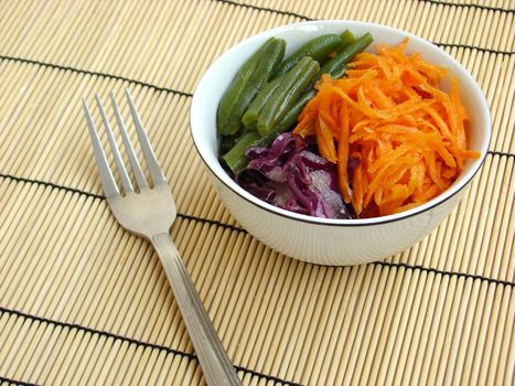 Fresh salad served with fork, ready to eat.