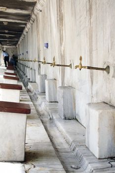 Ablutions on the marble fountain in courtyard fountain at The Sultanahmet Mosque (Bleu Mosque) in Istanbul