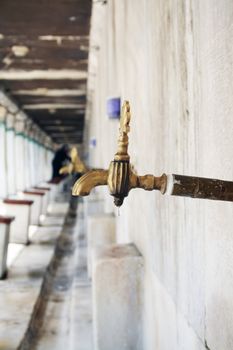 Ablutions on the marble fountain in courtyard fountain at The Sultanahmet Mosque (Bleu Mosque) in Istanbul