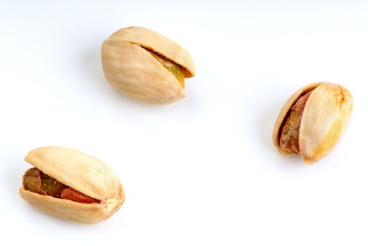 Salted three pistachios isolated on white background