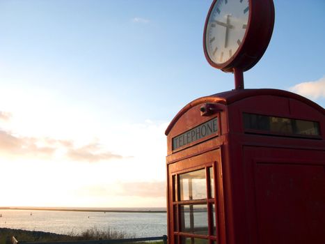 Red telephone box with view at sea
