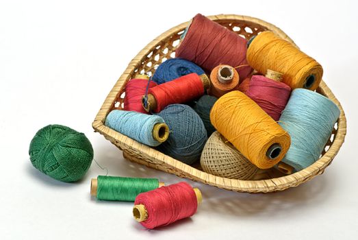 
thread spool and  bobbin
 in wooden basket