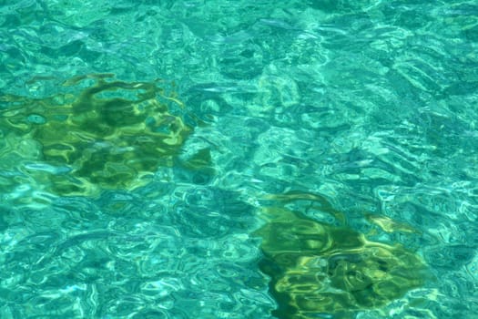 An abstract shot of the water at Georgian bay, featuring a couple of dark stones.