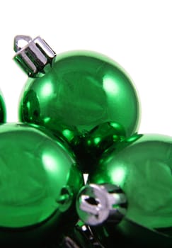 A bunch of green Christmas baubles against a white background.
