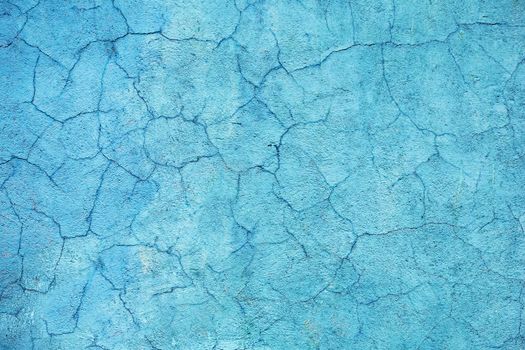 Concrete walls are covered with blue paint with cracks