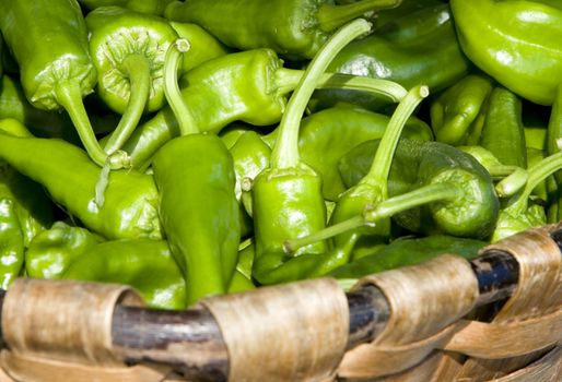 vegetal fresh green peepers inside of a wooden basket