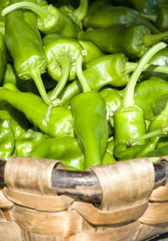 vegetal fresh green peepers inside of a wooden basket