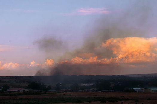 Grass fire out of control sends clouds of smoke into the sunset sky