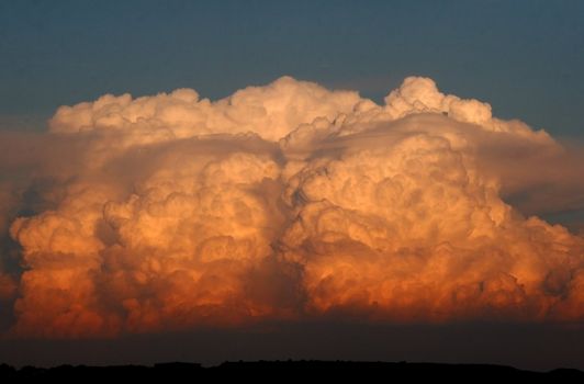 Giant cumulus nimbus cloud building at sunset