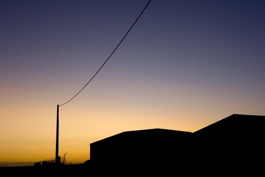 image of power wires and buildings at sunset