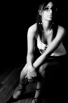 Black and white photo of a twenty something fashion model sitting on office chair with secretary style