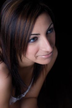 Close up portrait of a twenty something fashion model sitting on office chair with a shy smile