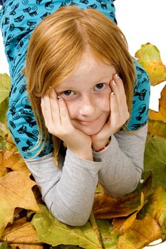red head girl laying in autumnl leafs