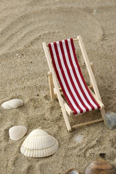 beach chair on the sand surrounded by shells