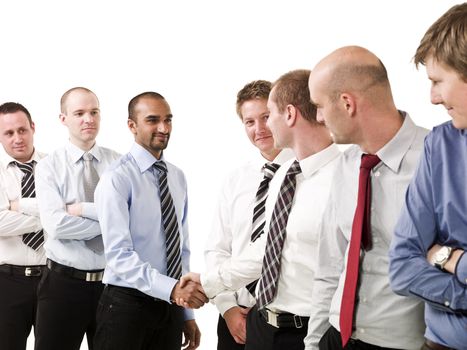 Businessmen shaking hands standing in a group of people