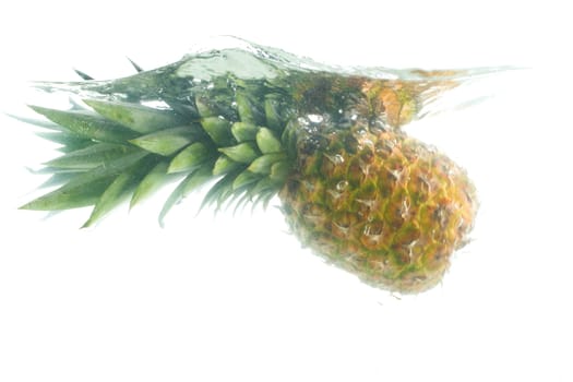 close-up pineapple falling in water, isolated on white