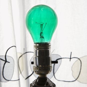 Close up of green light bulb in lamp.