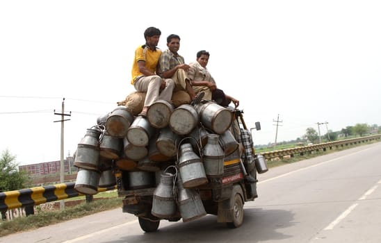 a road scene in India - small car with people and goods