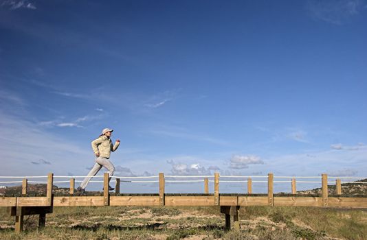 Young woman running alone in a sunny day