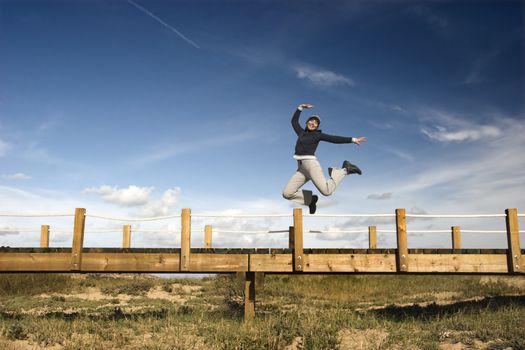 Young woman jumping for fun in a beautiful day