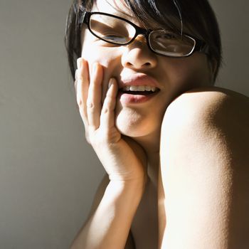 Head and shoulder portrait of pretty young Asian woman smiling.