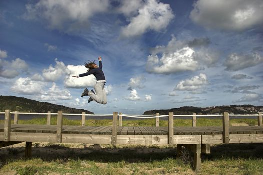 Young woman jumping for fun in a beautiful day