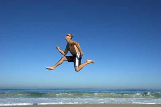 Man running and jumping on the beach
