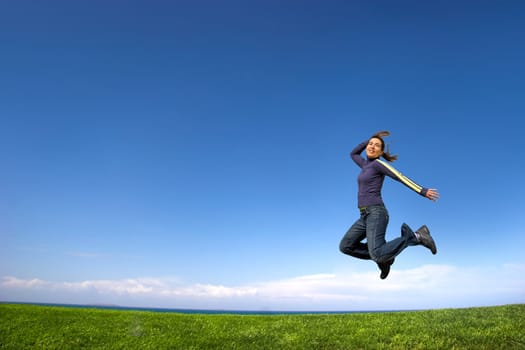 Young woman jumping on the green field