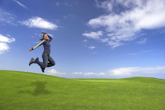 Young woman jumping on the green field