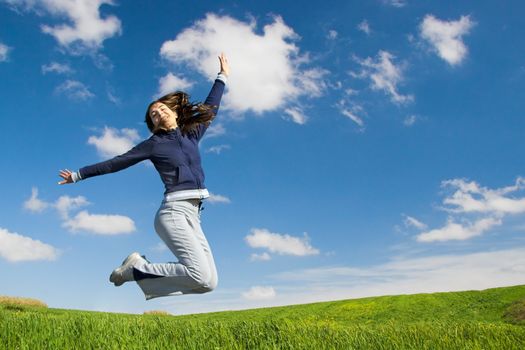 Young woman jumping in a green field