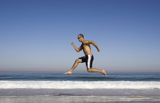 Man running and jumping on the beach