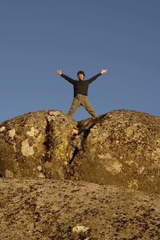 young man with arms wide open and the sky as background