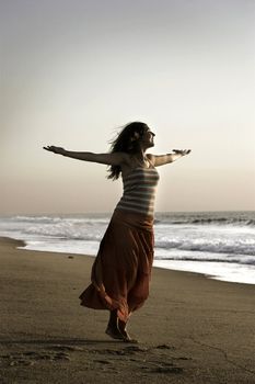Beautiful woman with open arms felling the wind