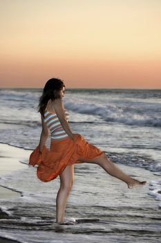 Woman in the beach spreading water