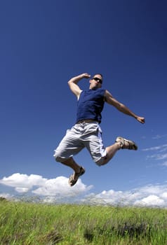Man make a big jump on a green meadow