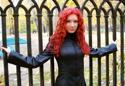 gothic style red hair woman near black grate