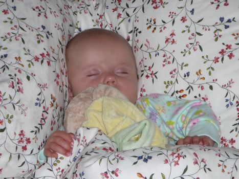 Baby caucasian girl sleeping in parent's bed.